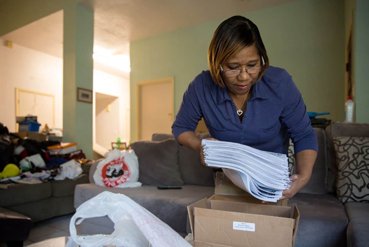 Tracy Ryans pulls out client applications containing private information that was mistakenly sent to her from the Texas Health and Human Services Commission, on April 24, 2018.  Pu Ying Huang for The Texas Tribune